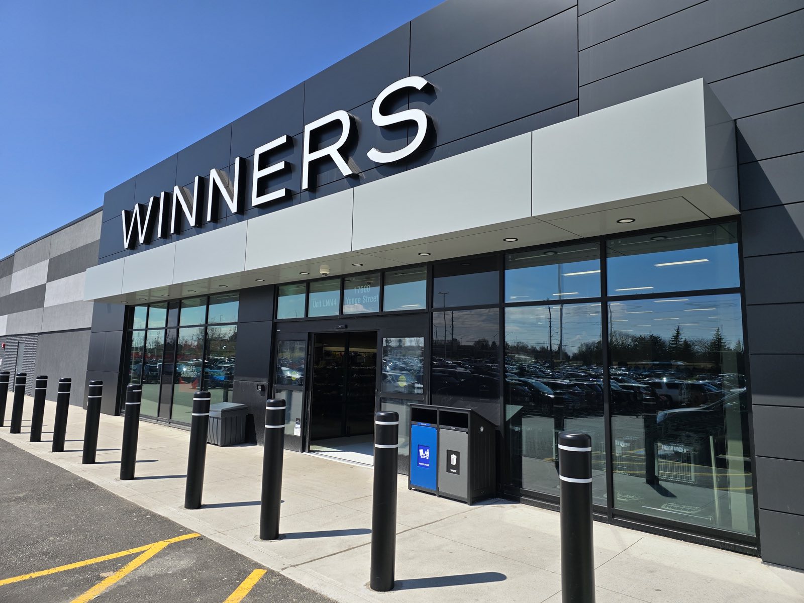 Light-grey canopy fascia running dead straight across a full storefront