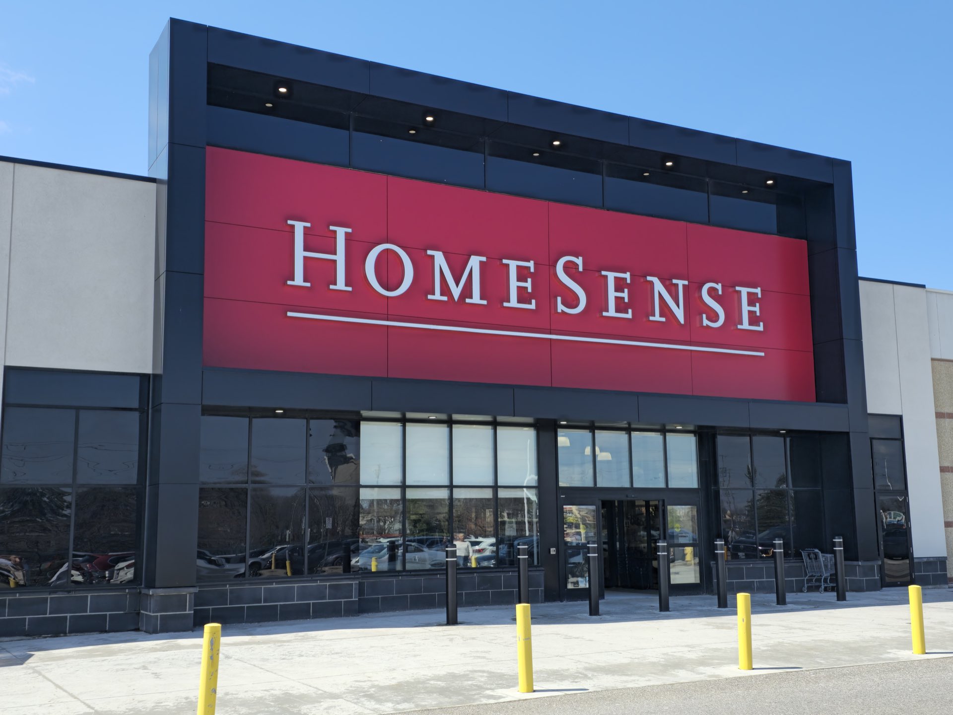 Completed retail elevation — red ACM panel field with square black frame surround
